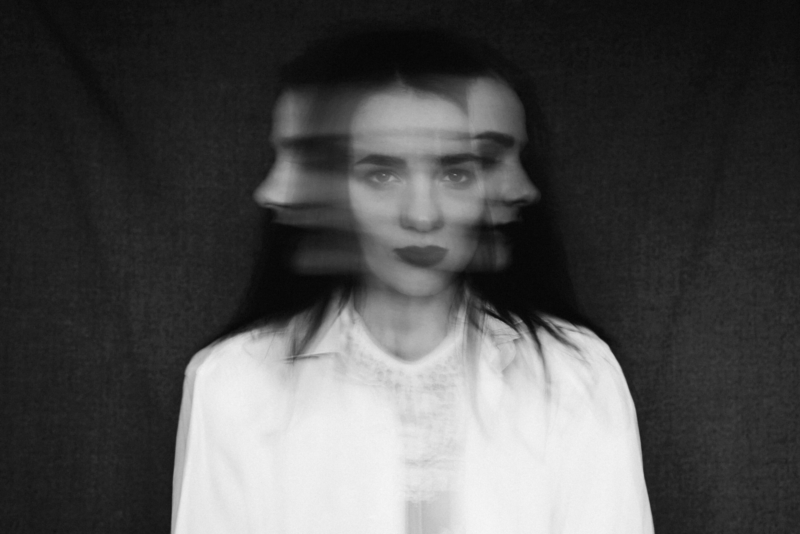 crazy portrait of girl with mental disorders and split personality. Black and white with added grain and motion blur Психические расстройства и внутренние конфликты